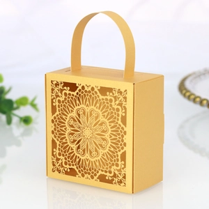 Detalle de caja dorada de boda cortada con láser con intrincado patrón de mandala
