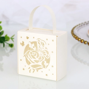 Detail of laser-cut rose and butterfly hollow patterns on ivory wedding candy gift box
