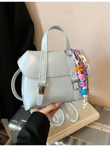 Light blue glossy leather backpack with colorful beaded charm and silver buckle detail