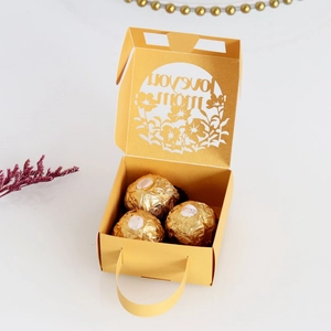 Macro detail of golden laser-cut gift box with Love you Mom design and chocolates