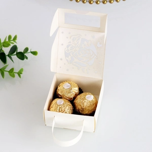 Detail of laser-cut butterfly and rose patterns on cream wedding favor gift box