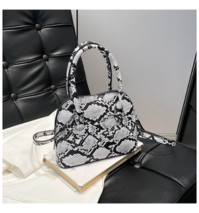 Detail of black and white snakeskin texture on a shell-shaped crossbody handbag