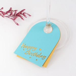 Detalle de tarjetas de copa Happy Birthday cortadas con láser en papel azul y dorado fino