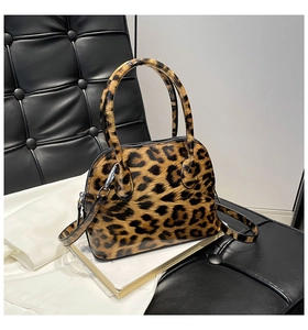 Detailed close-up of leopard print shell bag with glossy finish and detachable shoulder strap