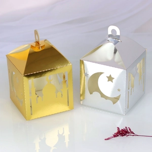 Close-up of gold and silver laser-cut Eid Mubarak paper gift boxes with mosque patterns