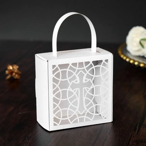 Détail de la boîte à bonbons en papier blanc découpé au laser avec motif de croix chic