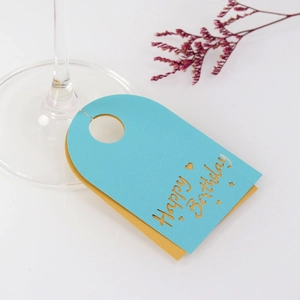 Tarjeta de copa de vino Happy Birthday azul y amarilla con letras huecas y estrellas