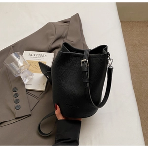 Detail of black lychee grain leather bucket bag with silver hardware and adjustable strap