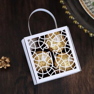 Détail de la boîte cadeau découpée au laser avec chocolat emballé dans une feuille d'or