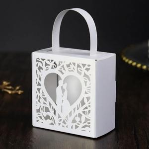 Detail of laser-cut wedding favor box with romantic heart-shaped couple silhouette