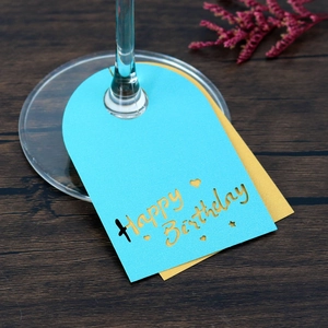 Detalle de tarjetas Happy Birthday cortadas con láser para copas en papel perlado azul