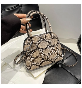 Detail of snakeskin pattern shell bag with silver hardware and adjustable strap