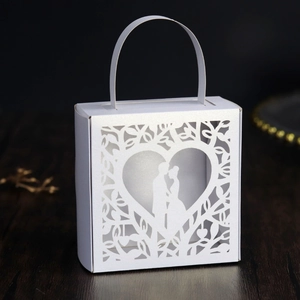 Detailed laser-cut white wedding favor box with heart and couple silhouette design