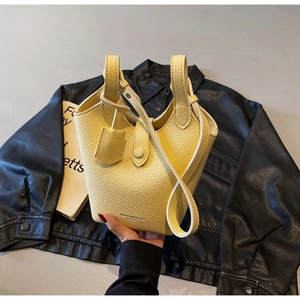 Detailed close-up of pale yellow lychee texture bucket bag with MUJIN&BAGS logo