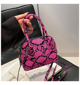 Detail of pink snake pattern shell bag with silver metal hooks and sturdy handles