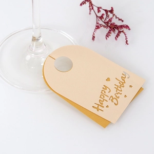 Detalle de tarjetas de mesa Happy Birthday para copas de vino con fondo dorado y letras