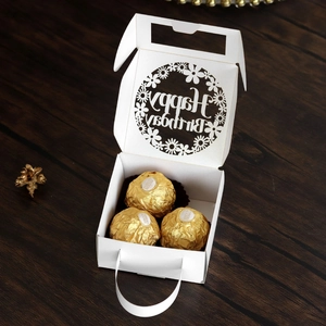 Detail of white laser-cut Happy Birthday candy gift box with elegant floral patterns