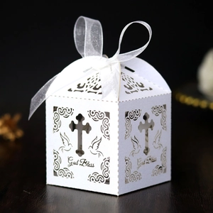 Detail of laser-cut gift box with God Bless text and white organza ribbon on wood