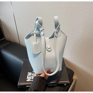 Detailed view of light blue lychee pattern leather bucket bag with top handle and strap