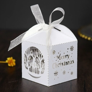 Détail de boîte de Noël blanche découpée au laser avec rennes et ruban en soie