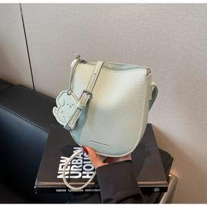Détail du sac selle vert menthe en cuir litchi avec breloque chien et fermeture éclair