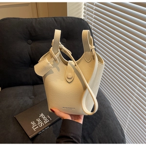 Detail of off-white lychee pattern leather bucket bag with top handle and MUONJIN logo