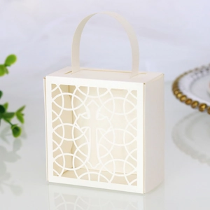 Détail de la boîte cadeau croix découpée au laser en papier perlé crème pour dragées