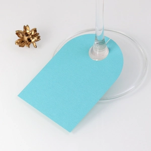 Detail of light blue arched place card with pearlescent finish for wine glass decor