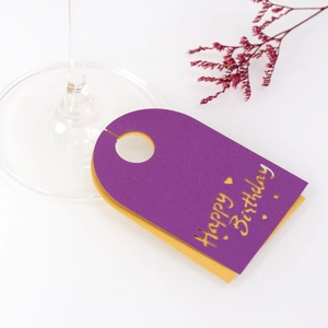Detalle de tarjetas Happy Birthday violetas para copas con forro dorado y patrones láser
