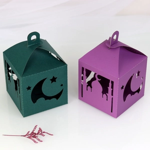 Detailed laser-cut Ramadan paper lanterns in green and purple with moon and star patterns