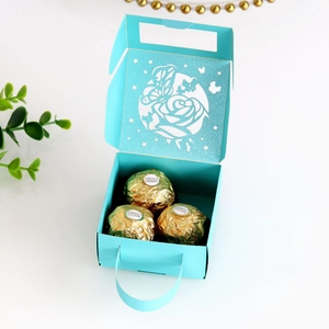 Detail of laser-cut butterfly gift box in turquoise with roses and chocolates