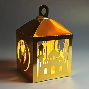 Detail of golden laser-cut lantern with mosque silhouettes and warm LED light