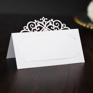 Detailed laser-cut pattern on elegant white hollow folding place card for weddings