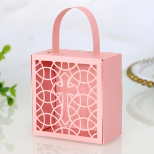 Détail de boîte à bonbons rose découpée au laser avec motif de croix et forme de sac