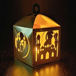 Golden laser-cut moon and mosque paper lantern with warm glowing interior light
