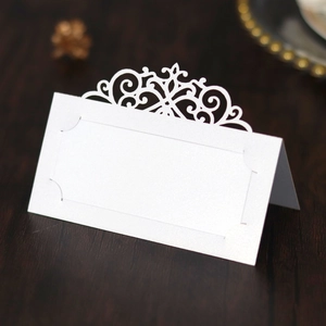 Detailed macro view of laser-cut floral pattern and name blank on white place card