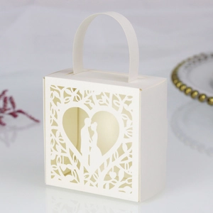 Macro view of white laser-cut wedding candy box featuring a heart-shaped silhouette