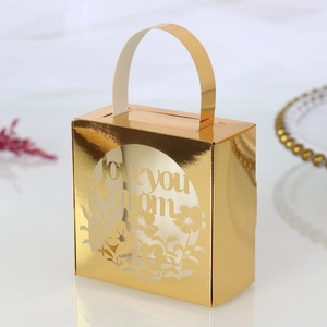 Detail view of gold laser-cut candy box with Love You Mom floral hollow design