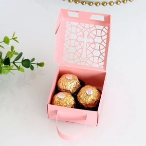 Vue détaillée de la boîte cadeau rose découpée au laser avec motif croix évidé