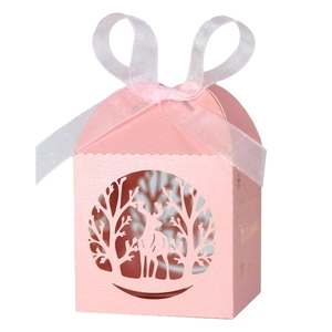 Détail d'une boîte cadeau de Noël rose découpée au laser avec renne et ruban blanc élégant