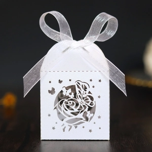Detailed laser cut white candy box with rose patterns and a delicate organza ribbon bow