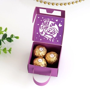 Macro view of purple laser-cut rose and butterfly hollow design on paper favor box