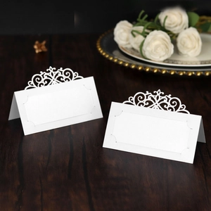Detailed laser-cut scroll pattern on white hollow place cards for wedding table seating
