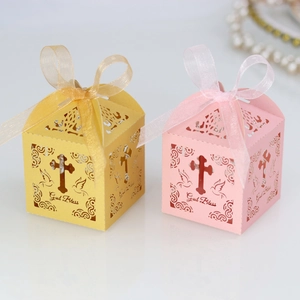 Detail of laser-cut candy boxes with God Bless text, holy cross and dove motifs