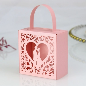Detail of pink laser-cut wedding favor box with heart silhouette and pearl finish