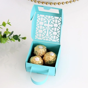 Détail de la découpe laser en croix sur boîte cadeau bleu clair avec chocolat