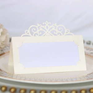 Macro detail of laser-cut cream pearl paper place card with elegant European pattern