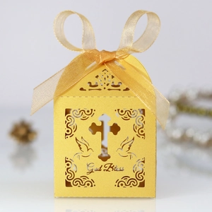 Detail of laser-cut cross and God Bless text on gold paper gift box with ribbon