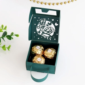 Detail of dark green paper gift box with laser-cut rose and butterfly hollow patterns