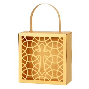 Gros plan de la boîte cadeau dorée avec croix découpée au laser et motif géométrique